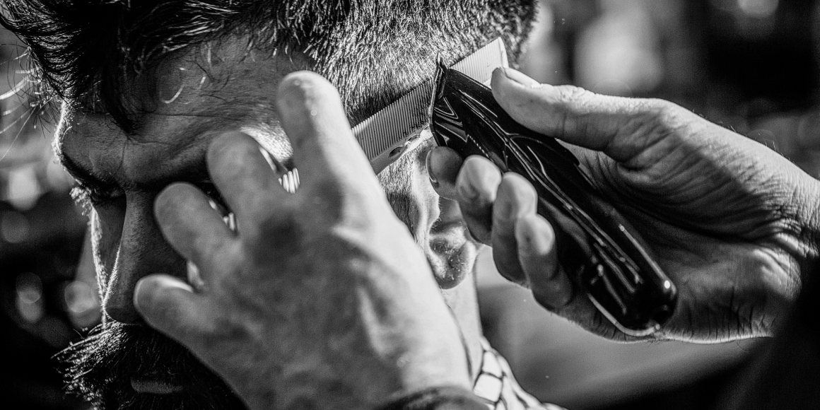 barber cutting client hair using trimmer