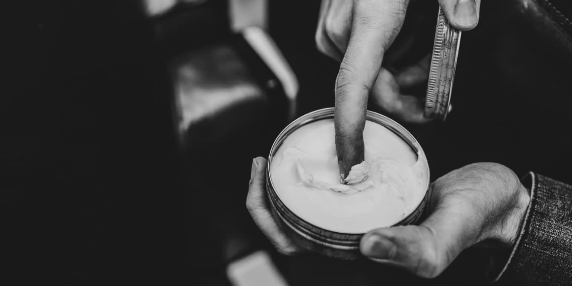 barber using pomade to hair styling